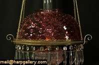   cranberry glass shade that appears original the solid brass frame has